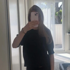 Mörkgrå stickad tröja från Vero Moda - Mysig mörkgrå stickad tröja från Vero Moda med rund halsringning och halvlånga ärmar. Tröjan har en lite boxig passform och är perfekt att slänga på sig när det är kyligt. 