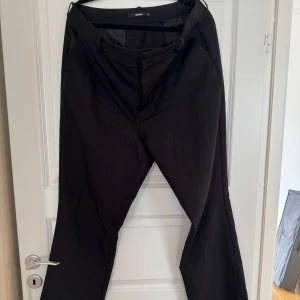 Svarta kostymbyxor från Bik Bok  - Svarta kostymbyxor från Bik Bok med raka ben och klassisk passform. Byxorna har hällor för bälte, diskreta sidofickor fram och fuskfickor bak. Utsvänga. Perfekta för en clean och stilren look. Byxa Wilma storlek 48 