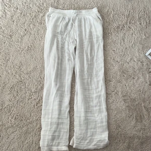 Vita linnebyxor med dragsko - Luftiga vita linnebyxor med rak passform och elastisk midja med snörning. Perfekta för varma dagar och chill vibes. Tunt, svalt tyg som ger en avslappnad look.