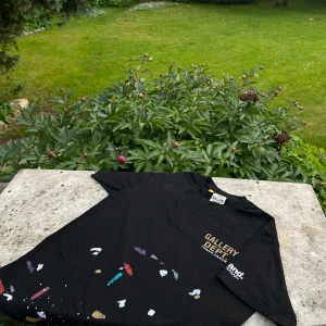Gallery Dept t-shirt  - Svart t-shirt från Gallery Dept. med tryck 'GALLERY DEPT. TOKYO, JAPAN' på bröstet och färgstänk i rött, blått, lila, vitt och guld över hela framsidan. Klassisk passform och rund hals. Perfekt för dig som gillar streetwear med konstnärlig vibe. Jag har använt t shirten ca 7 ggr men inget på den tyder på slitage, skick 9/10✅ Om du undrats något är det bara att skriva, svarar så snabbt jag kan😁🙌✅
