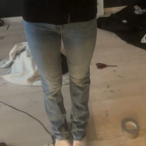 Blå bootcut jeans - Snygga blå bootcut jeans med råa kanter. De har en klassisk femficksdesign och knappgylf. Perfekta för en avslappnad stil.