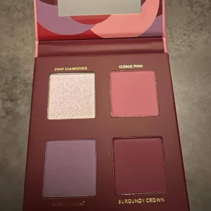 Ögonskuggspalett i rosa och lila toner - Palett med fyra ögonskuggor: skimrande ljusrosa (Pink Diamonds), matt rosa (Iconic Pink), matt lila (Legacy Lilac) och djup burgundy (Burgundy Crown). Kommer i en snygg förpackning med spegel och grafiskt mönster i rosa och rött.