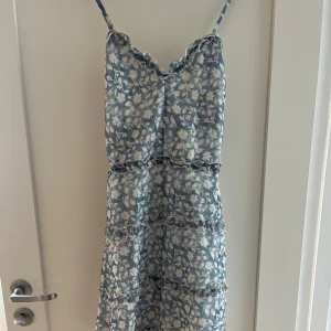 Blåvit blommig kortklänning  - Jättesöt blåvit blommig klänning från ASOS. Låg rygg med korsade band. Perfekt till sommaren!💙💙