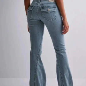Bootcut jeans i ljusblå denim - Säljer mina True Religion jeans eftersom jag ej använder de, litet hål med slitningar längst ner då dom var för långa på mig 157cm. Storlek W26
