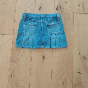  Populär Jeanskjol från Tommy Hilfiger - Snygg blå jeanskjol från Tommy Hilfiger med klassiska fickor både fram och bak, samt coola pressveck bak. Kjolen har bälteshällor och logga på fickan. Perfekt för dig som gillar en tidlös och avslappnad stil köpt helt ny!❤️.