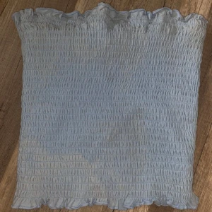 Ljusblå bandeau tubtopp med volang - Supersöt ljusblå bandeau tubtopp med smockad struktur och volangkant upptill och nedtill. Perfekt för sommaren. Toppens stretchiga material gör den bekväm och lätt att bära❤️