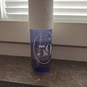 Sol de Janeiro Cheirosa 59 Parfymmist - Fräsch parfymmist från Sol de Janeiro i doften Cheirosa 59. Flaskan är cylindrisk med lila transparent glas och stor vit kork. Doften har inslag av vaniljorkidé, sockrad viol och sandelträ. Perfekt för dig som gillar söta och blommiga toner. Använt en del gånger men inte längre.