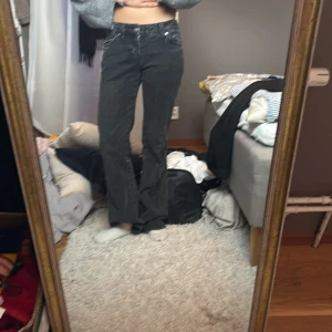 Svarta bootcut jeans med fickdetaljer - Säljer ett par svarta bootcut jeans med snygga fickdetaljer bak och klassisk femficksdesign. Jeansen har låg midja och är i ett mjukt denimtyg som ger en avslappnad vibe. Perfekta för dig som gillar en tidlös men trendig look. Använt fåtals gånger💞🌺