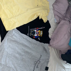 Svart t-shirt med hockeytryck från Polo Ralph Lauren - Svart t-shirt från Polo Ralph Lauren med färgglatt tryck av en björn i hockeyutrustning på framsidan. Klassisk passform och rund halsringning. Perfekt för dig som gillar sportiga och lekfulla plagg. Och Morris t shirt plus en peak