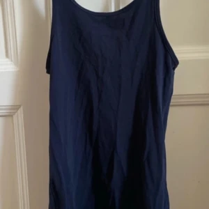 Mörkblå ärmlös linnetopp - Säljer en stilren mörkblå ärmlös linnetopp. Perfekt för varma dagar eller som lager under en tröja. Enkel och mångsidig design! 