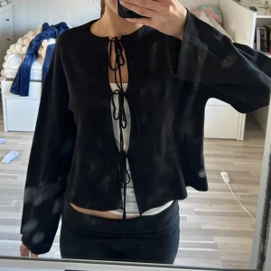 Svart kofta - Säljer denna jätte söta koftan med rosett knytningar från gina tricot. Den är helt ny med lappar kvar, säljer då jag inte får någon användning för den!💓