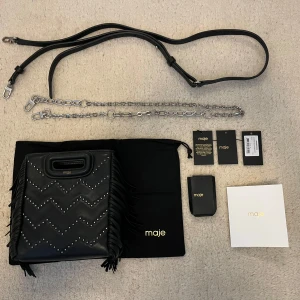 Maje väska mini - Maje väska med studds i ett zick-zack mönster som är köpt hösten 2021 i marbella. Väskan köptes för 250 euro som då va runt 2500kr ungifär. Nu kostar en liknande väska runt 3000kr. Väskan kommer med en kedja och ett läderband. Kedjan är aldrig använd men läderbandet och delarna på väskan där bandet ska hakas fast har lite rost som inte syns när väskan används. Längst ner på väskan finns et litet rivmärke på cirka 2 cm som bara syns i speciella ljus. Annars i väskan i toppskick!