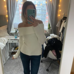 Vit offshoulder tröja - Säljer en stilren vit offshoulder tröja med lång ärm. Perfekt för en chic och avslappnad look. Tröjan har en ribbad struktur som ger en snygg passform. Passar utmärkt till jeans eller kjol för en trendig outfit.