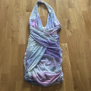 Ljuslila omlottklänning från Zara - Säljer en ljuslila omlottklänning från Zara med halterneck och draperad effekt. Klänningen har en kort längd och v-ringad halsringning. Perfekt för sommarens tillfällen och har en snygg, figurnära passform. Mer som en S. 