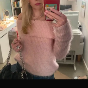 Ljusrosa fluffig offshoulder-tröja - Supermjuk och fluffig ljusrosa tröja med offshoulder-modell och långa ärmar. Perfekt för dig som vill ha en söt och trendig look. Tröjan har en bred kant upptill och är riktigt gosig.storlek M men sitter som en S