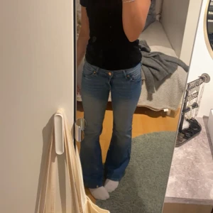 Blå lågmidjade bootcut jeans - Säljer ett par klassiska blå bootcut jeans med lågmidja och normal passform. 