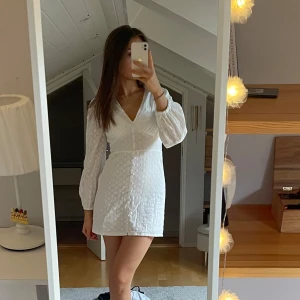 Studentklänning - Superfin vit klänning med v-ringning, långa puffärmar och broderade blommor. Perfekt till studenten eller sommaren! Helt oanvänd, säljer då jag ska ha en annan klänning. Pris går att diskutera vid snabb affär💞💞 