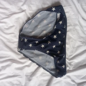 Mörkblå bikiniunderdel med stjärnmönster - Säljer en mörkblå bikiniunderdel med vita stjärnor över hela tyget. Klassisk modell med normal passform och elastiska kanter. Perfekt för strand eller poolhäng i sommar!