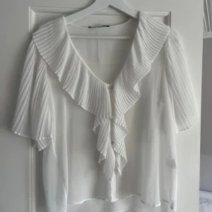 Zara topp  - Fin vit topp från Zara med volang, perfekt till sommaren! Helt oanvänd i storlek xs! 