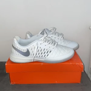 Nike HypervenomX Finale II IC – Inomhusskor (Helt Nya) -    Säljer ett par helt nya och oanvända Nike HypervenomX Finale II IC inomhusfotbollsskor i vitt och grått. Stilrena och bekväma skor som är perfekta för futsal eller annan inomhusträning. Ovandelen ger bra bollkontroll och passform, medan sulan är anpassad för optimalt grepp på inomhusgolv.  Skick: Helt nya, aldrig använda Storlek: 41 Nypris: Ca 1000 kr Mitt pris: 800 kr Levereras i originalkartong. 
