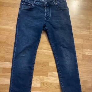 Mörkblå jeans från Jacob Cohën - Snygga mörkblå jeans från Jacob Cohën med knappgylf och stilren design. Byxorna har en klassisk femficksmodell och märkesdetaljer på baksidan. Perfekta för en avslappnad men stilren look. Säljer dem eftersom jag precis beställde dem och dem var för korta. Jag är 188cm.