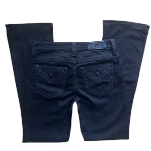 Svarta bootcut jeans från Miss Me - Snygga svarta bootcut midwaist jeans från Miss Me. Strl 28. Midjemått rakt över 74 cm, innerbenslängd 78 cm. Längd från skrev t midja: 24 cm.  Nypris 1100 sek 