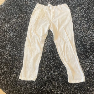 Beige linnebyxor med snörning - Säljer ett par bekväma beige linnebyxor med elastisk midja och snörning. Perfekta för en avslappnad stil. Byxorna har en loose passform och är tillverkade i ett lätt och luftigt material. Storlek m liten i storlek 