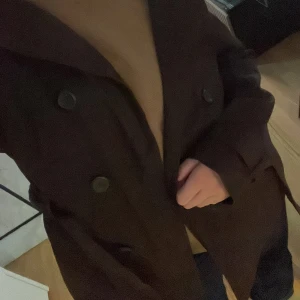 Brun kappa med bälte - Säljer en brun trenchcoat kappa med bälte och knappar. Står L, men sitter som en M.
