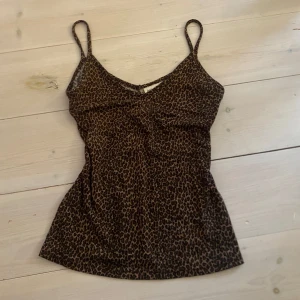 Leopardmönstrad linnetopp från Felicity - Snygg leopardmönstrad linnetopp från Felicity med smala axelband och v-ringning. Perfekt för en trendig look. 🐆