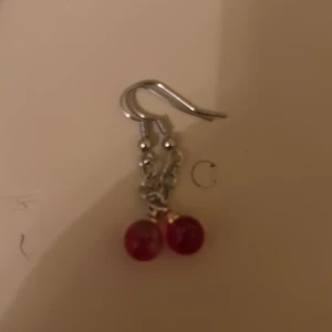 Örhängen med röda pärlor - Snygga örhängen med röda pärlor som hänger från en silverfärgad krok. Ej nickelfria! 