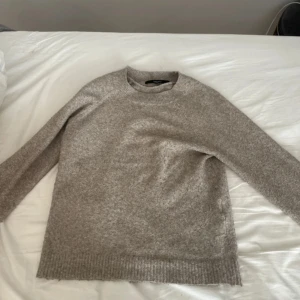 Beige stickad tröja från Vero Moda - Säljer en mysig beige stickad tröja från Vero Moda. Tröjan har en klassisk rund hals och långa ärmar, perfekt för kyliga dagar. Den är enkel och stilren, vilket gör den lätt att matcha med olika outfits.