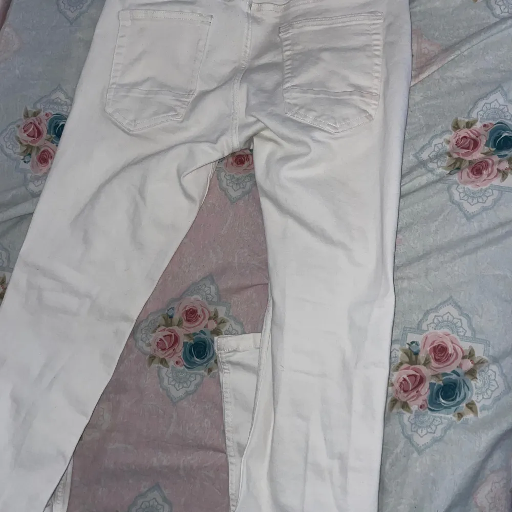 Säljer ett par vita jeans från Smog Denim. De har en klassisk femficksdesign med knappar och dragkedja framtill. Perfekta för en stilren look.. Farkut & Housut.
