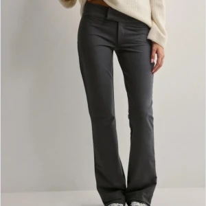 Grå low waist bootcut kostymbyxor!  - Snygga grå kostym byxor från Nelly med en stilren design. Bootcut med låg midja. Säljer dessa på grund av att de är förstora för mig. Extremt billigt pris för dessa fina byxor! Skriv till mig om ni vill ha mer bilder eller har någon fråga💗
