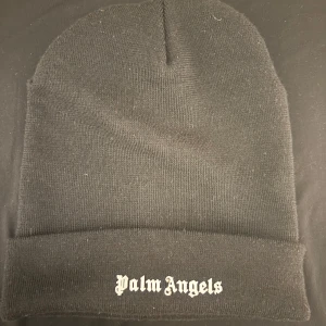 Svart Palm angels mössa  - Äkta Palm angels mössa, är i mycket bra skick nästan ny skick det är inget fel med mössan. Bara havt på mig cirka 3/4 gånger eftersom jag passa inte så bra i mössan och aldrig använder den. 