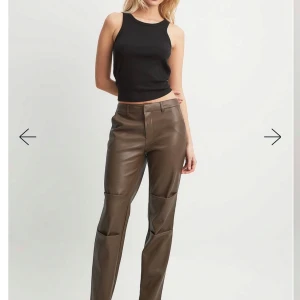Bruna skinnbyxor - Snygga bruna skinnbyxor med en stilren design. Byxorna har en rak passform och är perfekta för en trendig look. De har diskreta fickor bak och en smidig dragkedja fram.