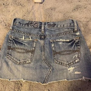 Abercrombie & Fitch kjol - Midjemått: ca 33 cm. Köpt från en annan på sellpy som sytt den mindre så skulle säga att den rymmer mindre och passar en xxs. Har defekter som visas då jag försökt sy ihop det. Pris kan diskuteras. 