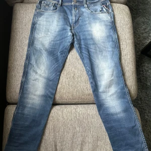Replay Anbass ljusblå jeans, stl W30 L32 - Säljer ett par Replay Anbass jeans i ljusblå tvätt med snygga slitna detaljer. Klassisk femficksmodell med raka ben och normal passform. Jeansen har Replay-logga på bakfickan och patch i midjan. Perfekta för dig som gillar en avslappnad stil. Hör av dig vid frågor eller funderingar! 