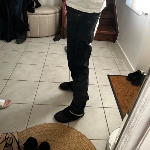 Svarta straight jeans  - Säljer ett par svarta jeans från Levi's med klassisk femficksdesign och raka ben. Jeansen har en normal passform och är tillverkade i robust denim. Perfekta för dig som gillar en enkel och tidlös look.