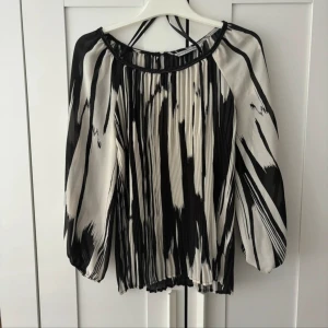 Svartvit blus - Supersnygg blus i jättefint skick! Knappt använd. Chiffong-liknande material. Står inte vilken storlek men gissar på M/L. Jag kan skicka mått!