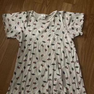 Vit blommig tshirt med volangärm - Supersöt vit tshirt från Lingon&Blåbär. Den har korta volangärmar och en avslappnad passform. 🩷 Är barnstorlek men är stor i storleken. 