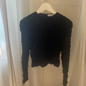 Svart långärmad blus från & Other Stories storlek 36 - Fin svart blus från & Other Stories i storlek 36. Med unik rynkad struktur. Långärmad modell. Jättebra skick.