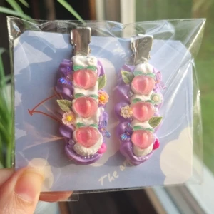 Krämlim Hårspännen  - Ett par hårspänn dekorerade med krämlim, persikor, blommor och fjärilar. Storlek 6 cm. 