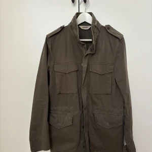 Aspesi field jacket  - Klassisk Aspesi field jacket i storlek XS, passar även S. Nypris cirka 8000kr. Mycket bra skick.  En liten söm har gått upp på jackan, se bild. Det är dock inget som syns och inget som påverkar funktionen (det är inte ett hål). Sömmen går med enkelhet att laga med nål och tråd alternativt hos en skräddare.