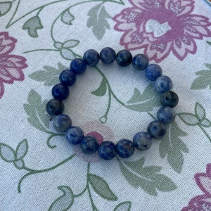 Blått pärlarmband med stenar - Snyggt armband med runda pärlor i olika nyanser av blått och grått. Pärlorna är trädda på elastisk tråd vilket gör det enkelt att ta på och av. Perfekt accessoar för att ge din outfit lite extra färg och stil. Prisförslag kan funka.