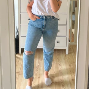 Ljusblå jeans - Säljer ett par snygga ljusblå jeans från H&M med rak passform och hög midja. Jeansen har en snygg slitning på ena knät samt en liten slitning som jag gjort själv precis under ena framfickan!🌸 Något små i storleken!☀️