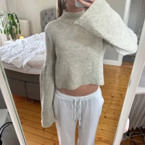 Beige croppad stickad tröja - Supermysig beige stickad tröja med breda ärmar och hög hals.