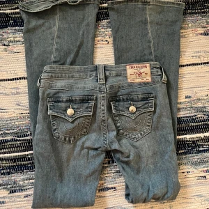 True Religion Jeans - True Religin Jeans i modell Joey.  Storlek: 24w L32  Perfekta jeans nu till skolstarten! Stilrena och trendiga. Jag har dratt ett skosnöre genom dom för att midjan ska vara justerbar. Visas på bild 5. Funkar utmärkt! Pris är diskuterbart. 
