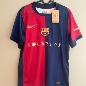 FC Barcelona Lamine Yamal matchtröja - Snygg FC Barcelona matchtröja från Nike med Lamine Yamal och nummer 19 på ryggen. Tröjan har klassisk halva-röd halva-blå design, klubbmärke på bröstet och guldfärgade detaljer. Tillverkad i lätt och ventilerande material, perfekt för fotbollsälskare.