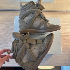 Isabel Marant skor  - Isabel Marant bekett leather wedge sneakers i storlek 38. Använda men fortfarande fint skick. Färgen heter ”taupe”. Inbyggd klack med höjd på 5 cm. Kartong medföljer. Nypris är 5750:-  kom gärna med prisförslag! 🤍