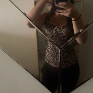 Leopardmönstrad linne från Zara - Säljer ett linne från Zara med snyggt leopardmönster i beige och svart. Modellen är ärmlös med smala axelband och croppad passform. Perfekt för dig som vill sticka ut med en trendig och djurinspirerad look. Den finns inte längre att köpa i butik eller online.